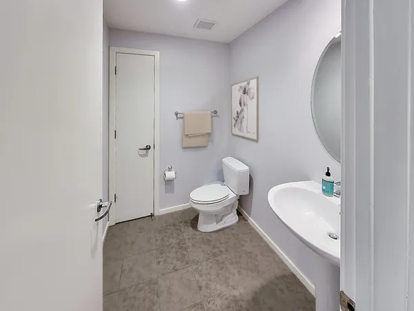 a spacious bathroom with a granite countertop sink a toilet and a mirror