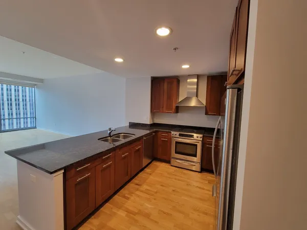 a kitchen with stainless steel appliances granite countertop a stove a sink and a refrigerator