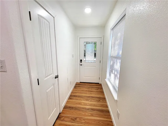 a view of a hallway with wooden floor and staircase