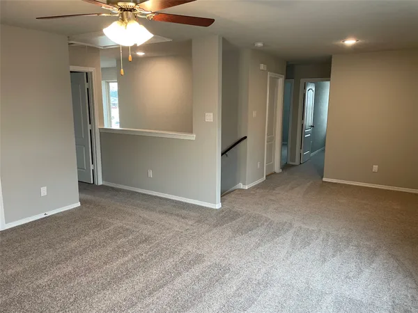 an empty room with closet and a chandelier fan