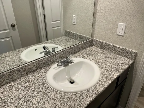 a bathroom with a granite countertop sink and a mirror