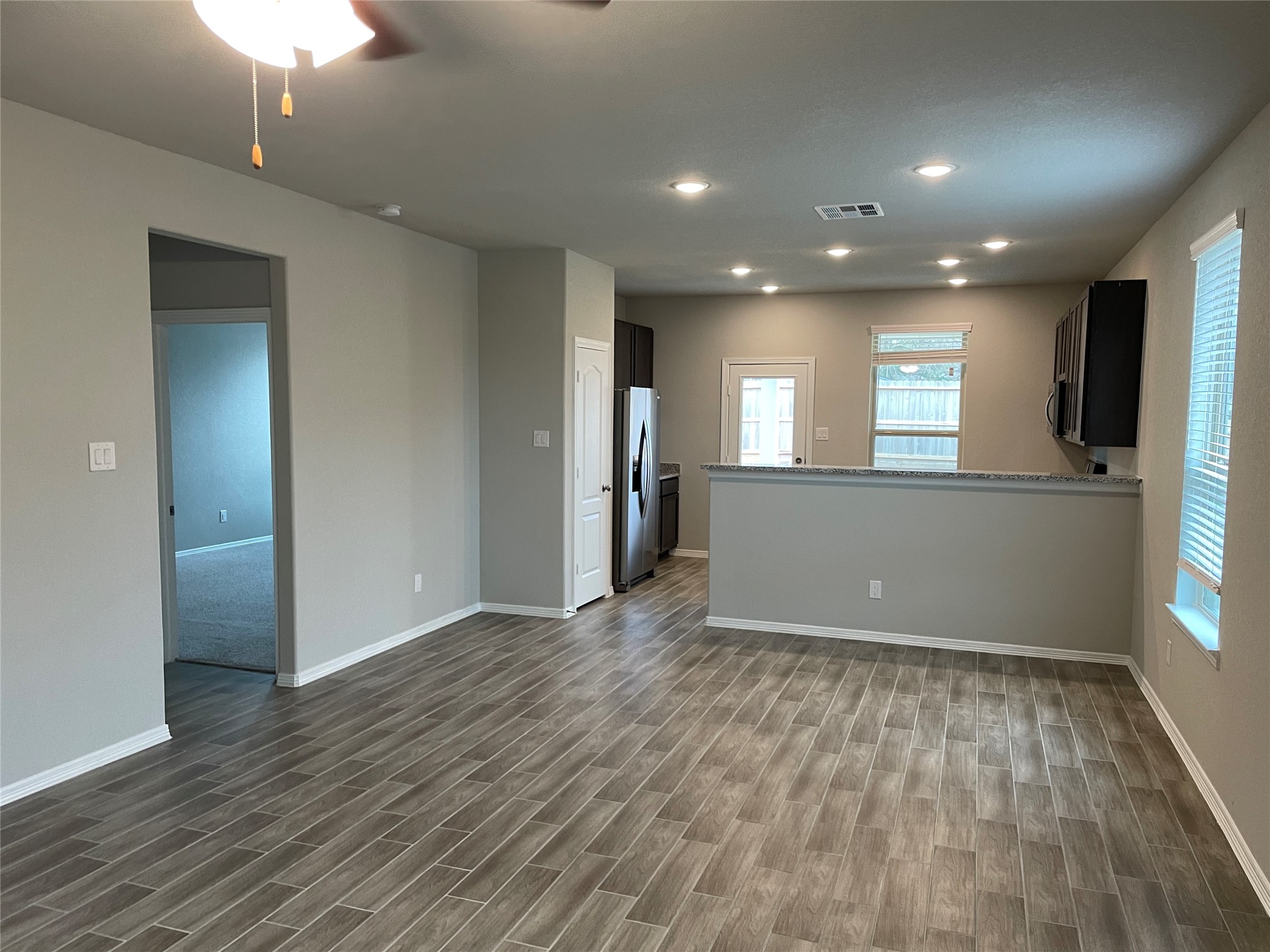 822 Redinger Ridge Drive Houston, TX 77336 - Photo 3 of 21 an empty room with wooden floor and a kitchen