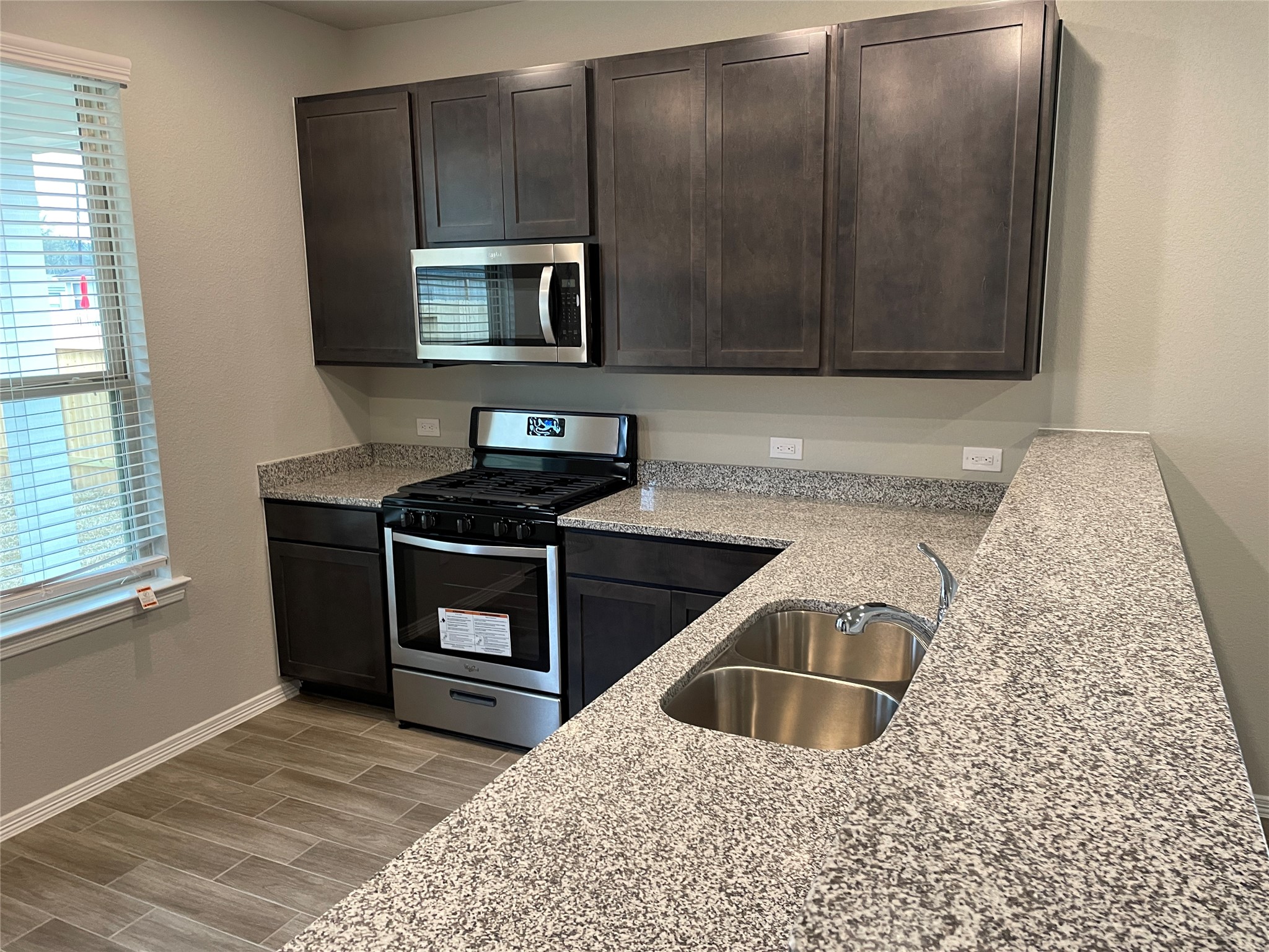 822 Redinger Ridge Drive Houston, TX 77336 - Photo 5 of 21 a kitchen with granite countertop a sink a stove and microwave