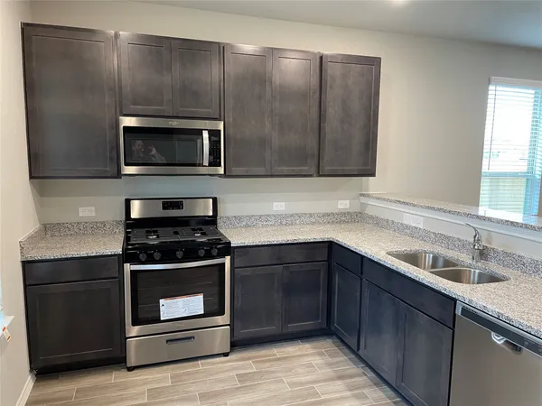 a kitchen with stainless steel appliances wooden cabinets and a stove top oven