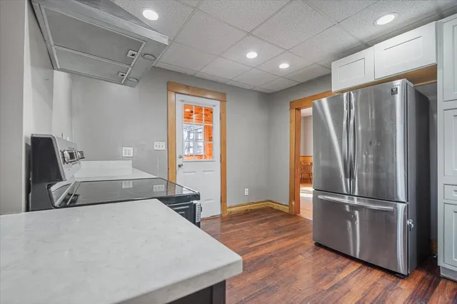 a kitchen with stainless steel appliances granite countertop a sink a stove and a wooden floors