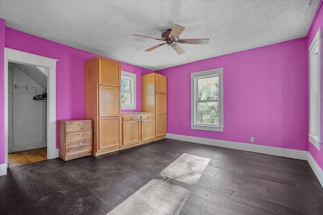 a view of empty room with window and ceiling fan