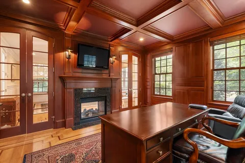 a living room with furniture pool table wooden floor and a fireplace
