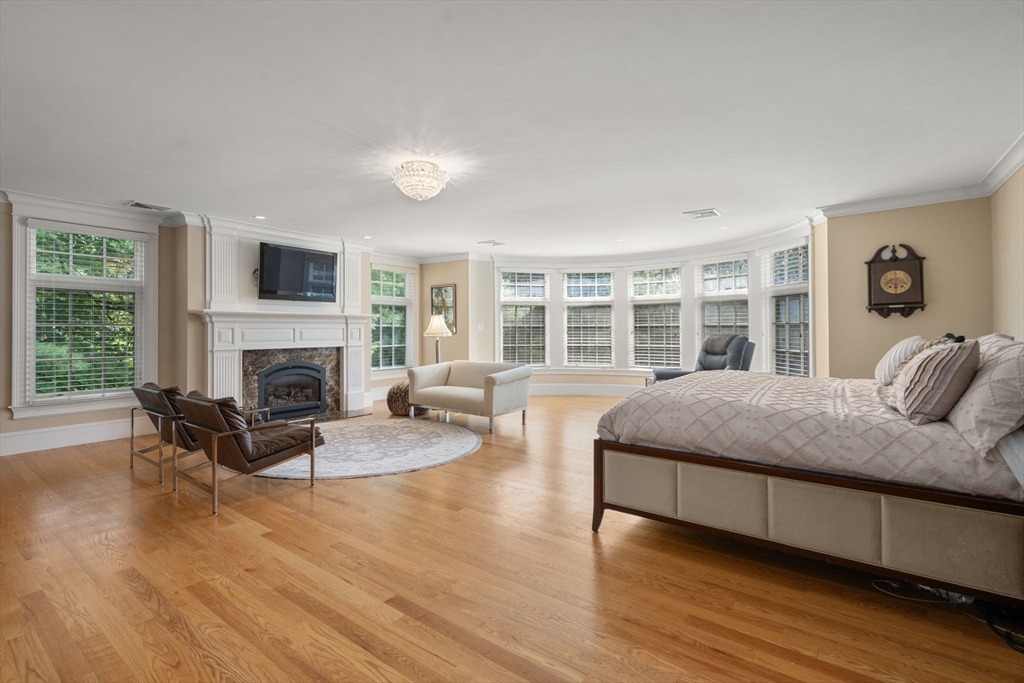 15 Rockport Road Weston, MA 02493 - Photo 10 of 20 a spacious bedroom with a large bed a flat tv screen and a fireplace