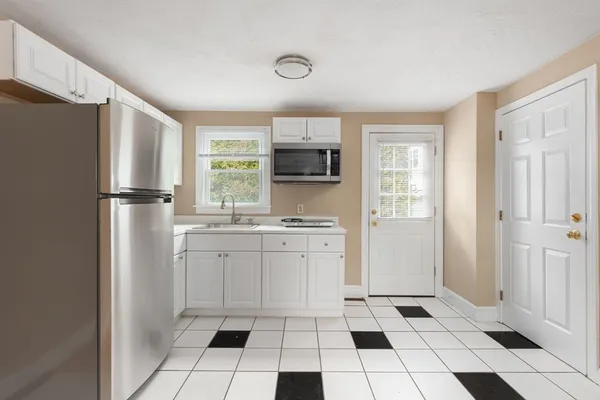 a kitchen with a refrigerator a stove top oven and cabinets
