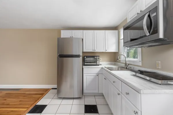 a kitchen with a sink a refrigerator and cabinets