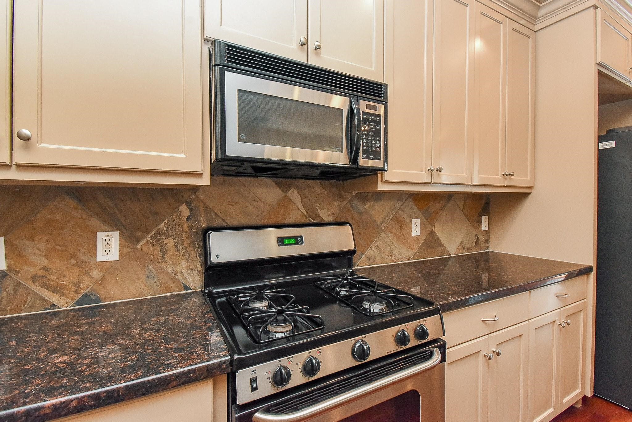 953 Yale Street, Unit 1 Houston, TX 77008 - Photo 7 of 24 a kitchen with granite countertop a stove and a microwave