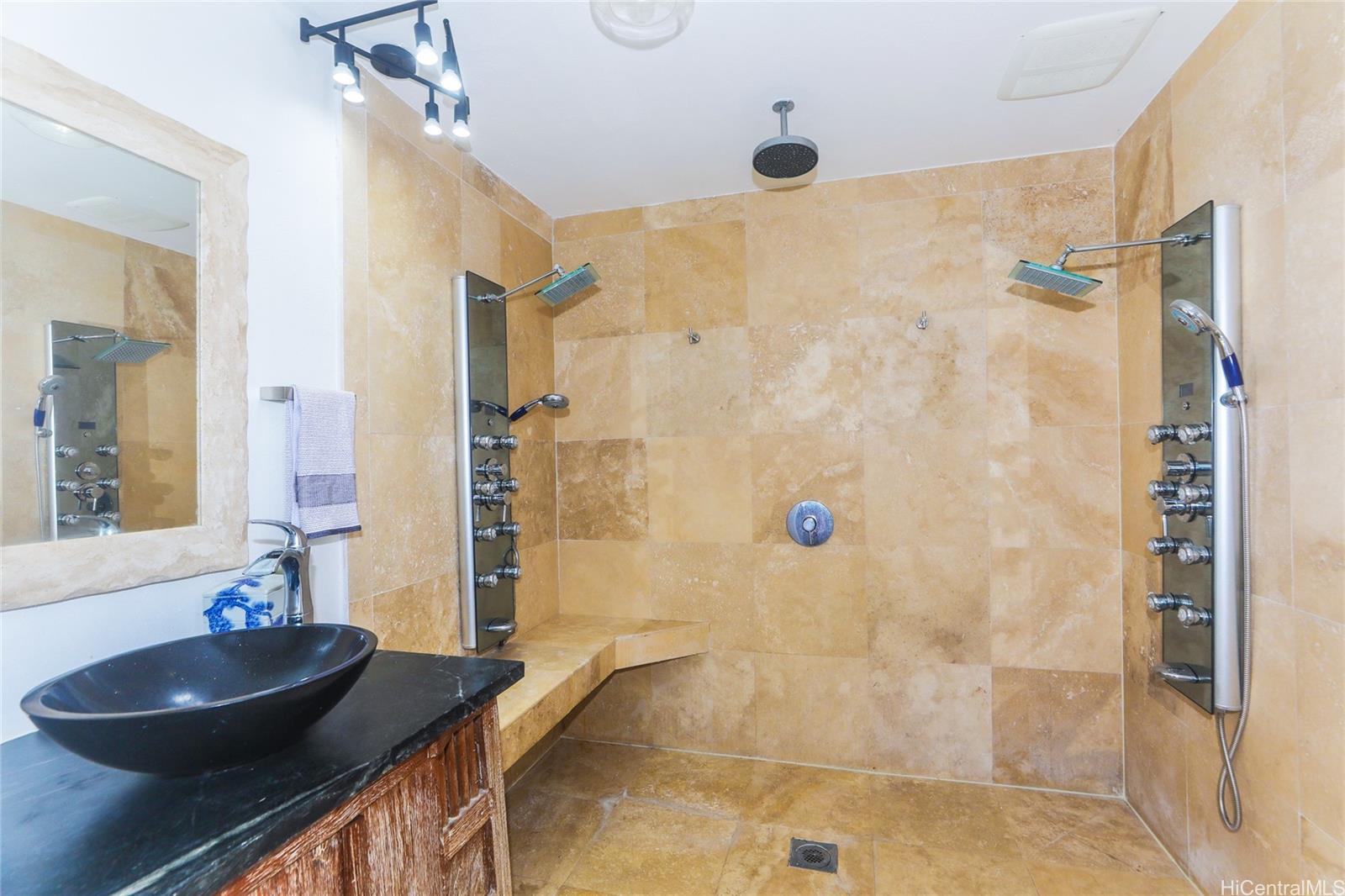 444 Lunalilo Home Road, Unit 312 Honolulu, HI 96825 - Photo 16 of 25 a bathroom with a granite countertop shower a sink and a mirror