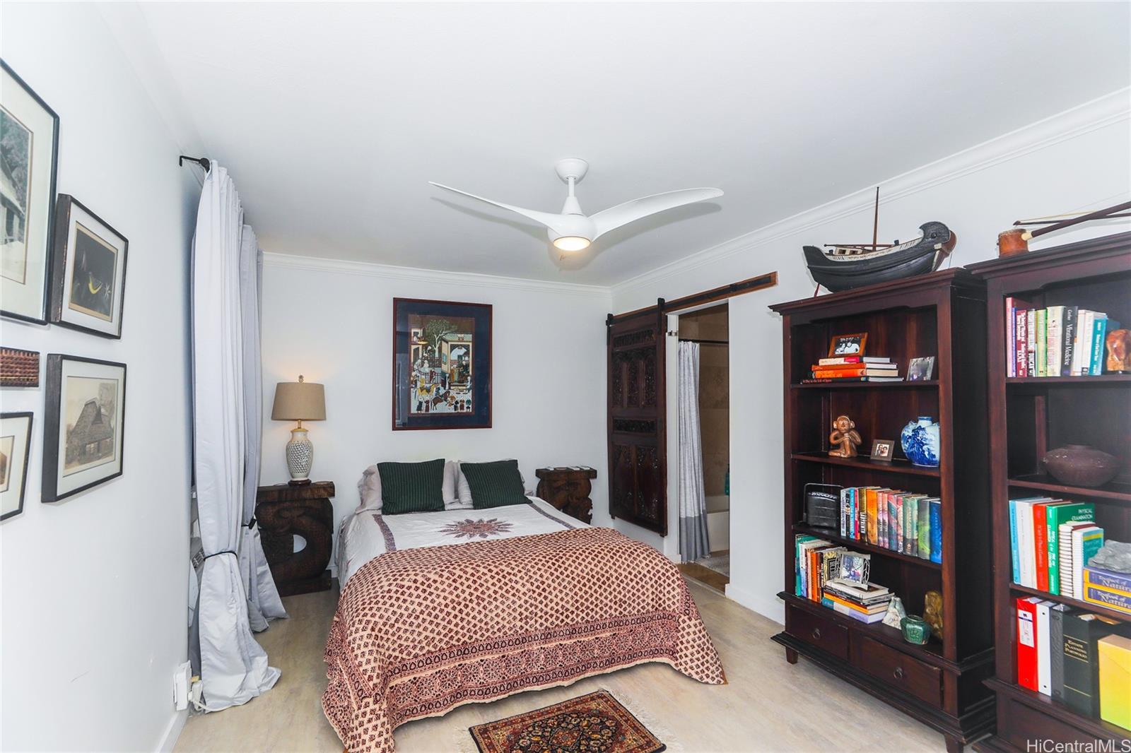 444 Lunalilo Home Road, Unit 312 Honolulu, HI 96825 - Photo 17 of 25 a bedroom with a large bed and a book shelf