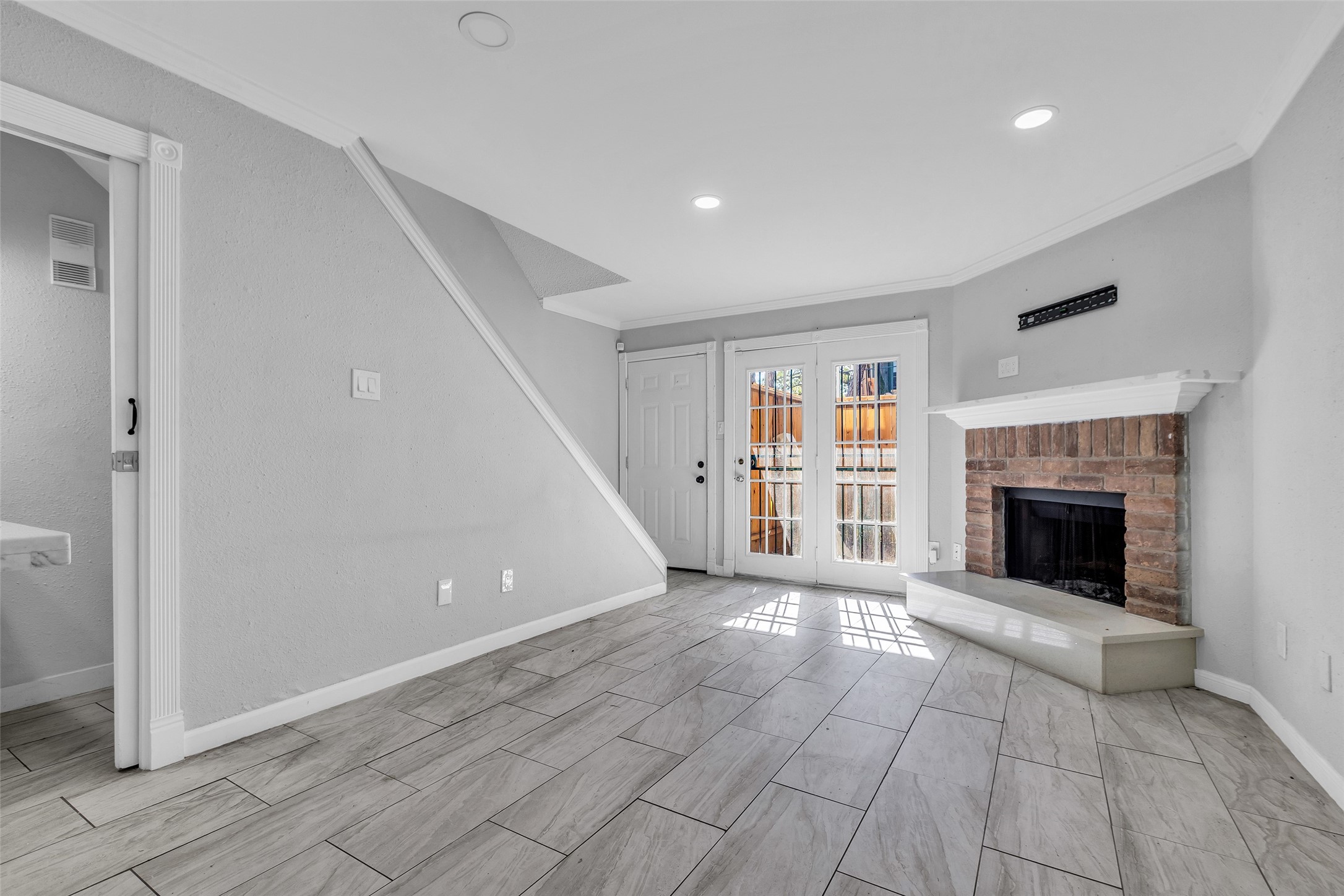 7402 Alabonson Road, Unit 301 Houston, TX 77088 - Photo 3 of 9 a view of an empty room with wooden floor fireplace and a window