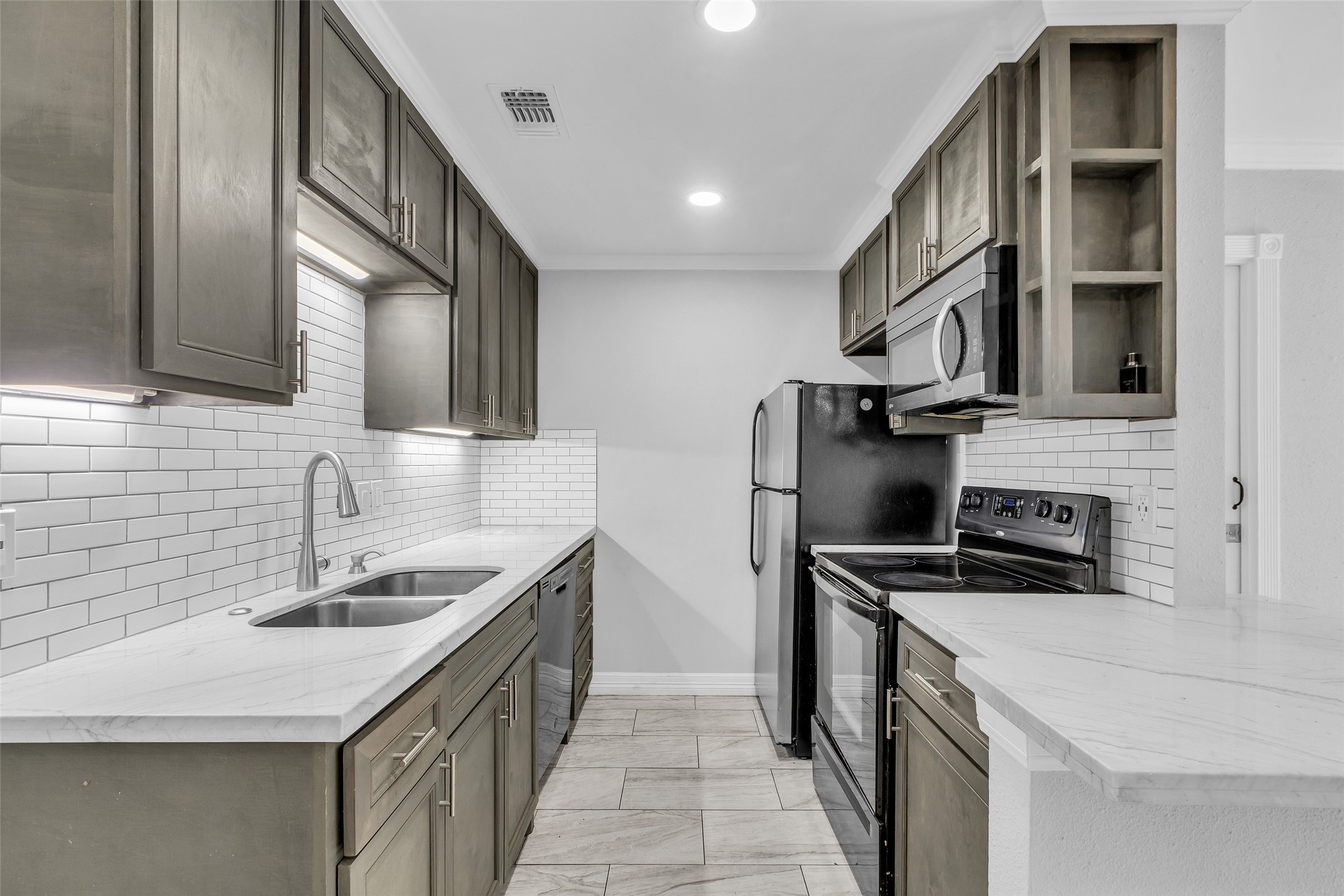 7402 Alabonson Road, Unit 301 Houston, TX 77088 - Photo 4 of 9 a kitchen with stainless steel appliances a sink stove and cabinets