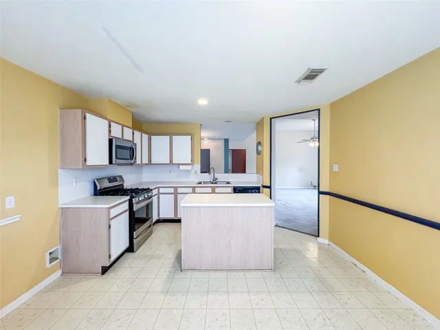 a kitchen with stainless steel appliances granite countertop a stove top oven a sink a counter top space and cabinets