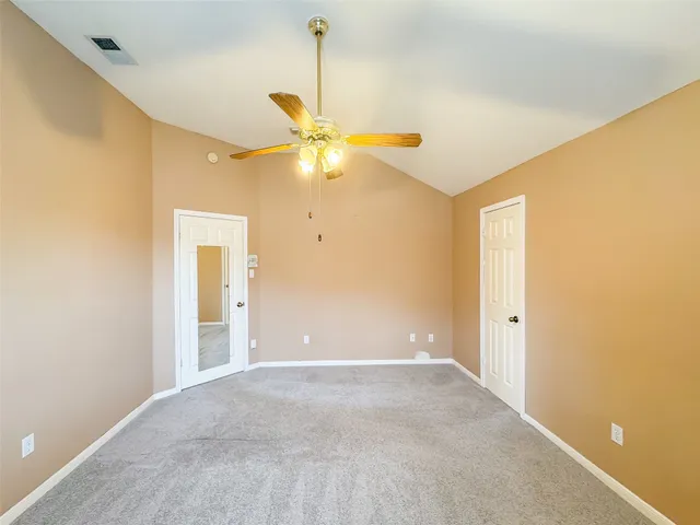 a view of an empty room with a ceiling fan