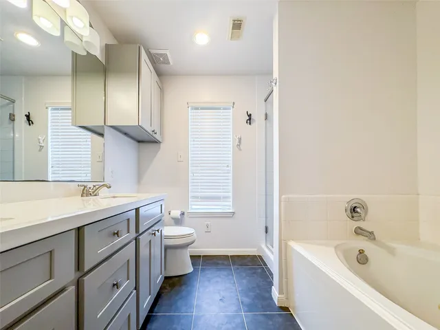 a bathroom with a tub sink and mirror