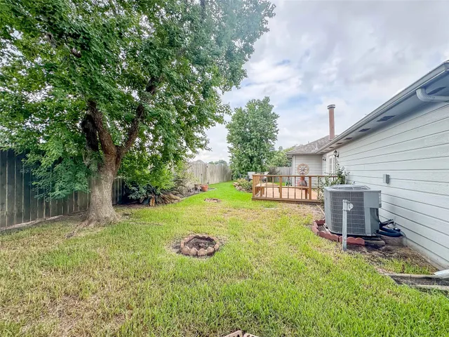 a view of a backyard with table and chairs and a large tree