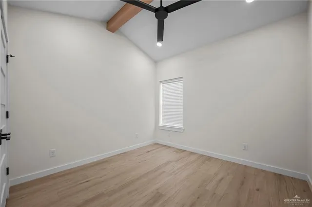 an empty room with wooden floor and ceiling fan