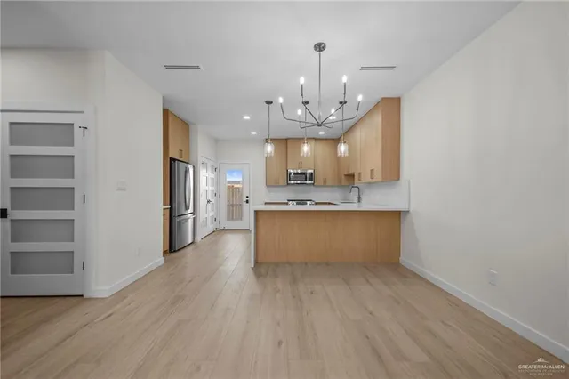 a large kitchen with a lot of counter space and stainless steel appliances