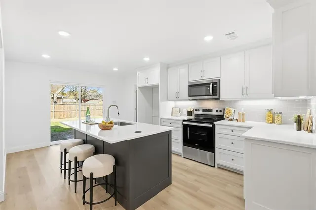 a kitchen with a stove a sink a dining table and chairs