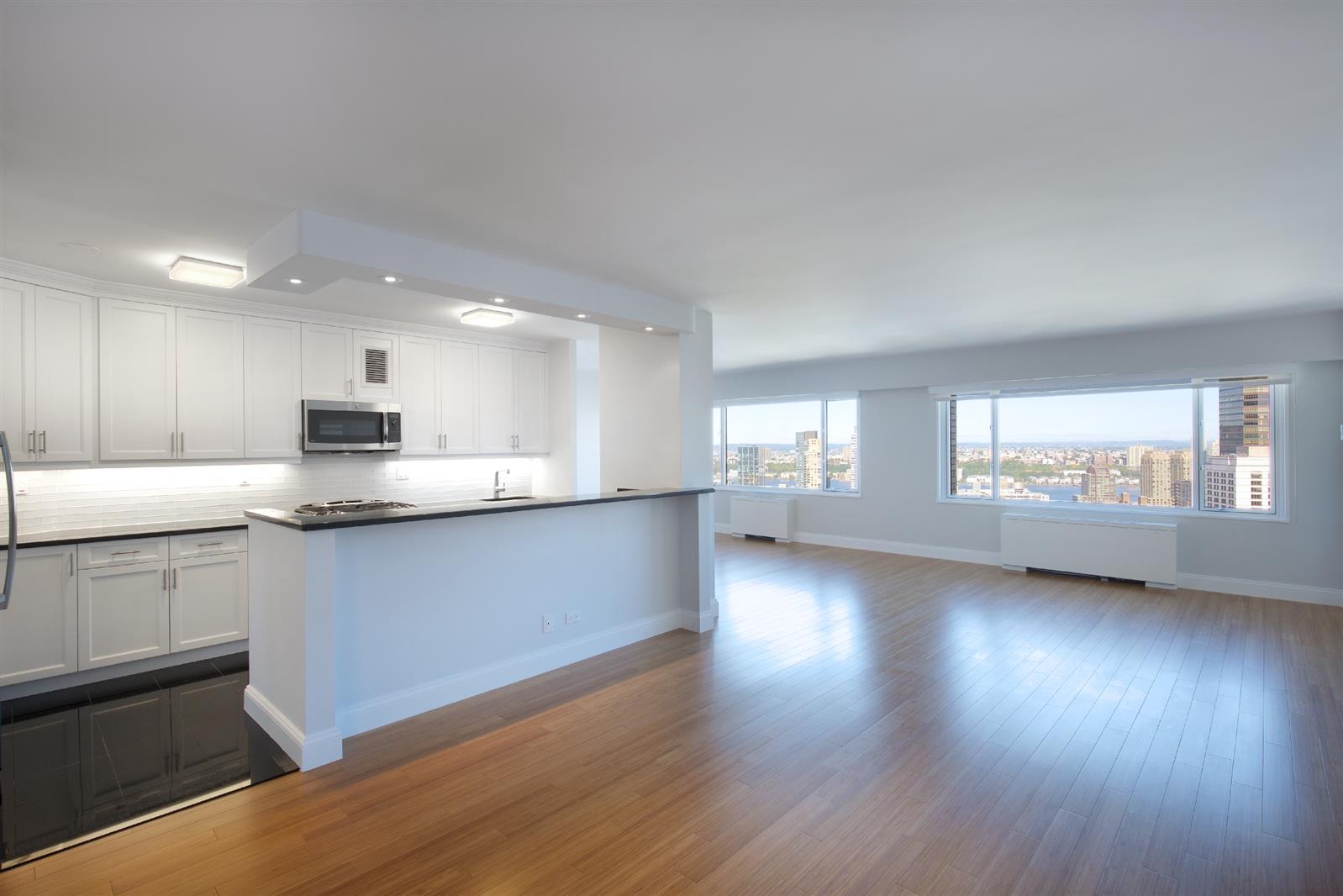 a large kitchen with hardwood floor and a view of kitchen