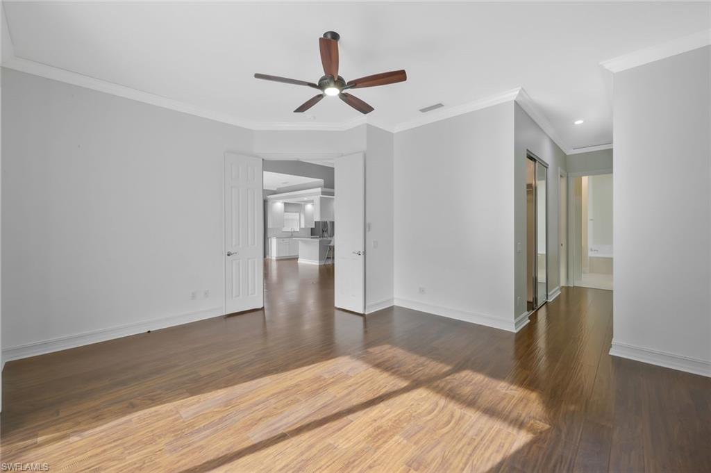 6044 Andros Way Naples, FL 34119 - Photo 13 of 46 Unfurnished room with baseboards, visible vents, wood finished floors, and a ceiling fan