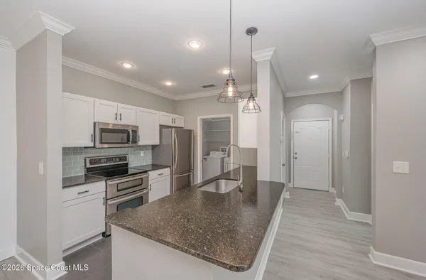 a large kitchen with stainless steel appliances granite countertop a sink and a stove