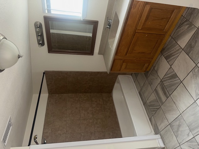 823 Monterrey Street Lockhart, TX 78644 - Photo 10 of 14 a bathroom with a bathtub sink vanity and mirror