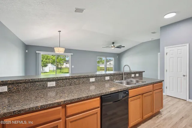 a kitchen with stainless steel appliances granite countertop a refrigerator a stove a sink and dishwasher