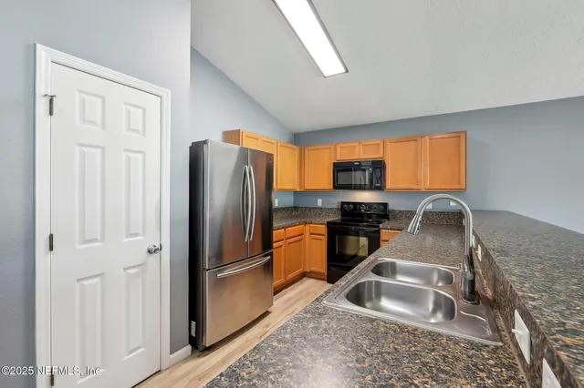 a view of a kitchen with a sink and a refrigerator