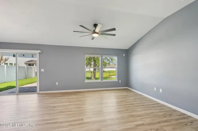 a view of an empty room with wooden floor and closet