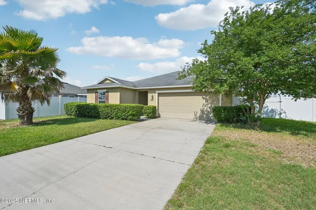a front view of a house with a yard and a garage