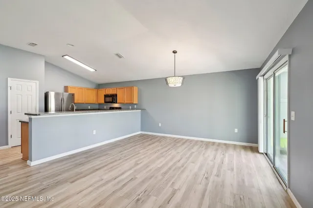 a view of a room with wooden floor and windows