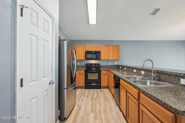 a kitchen with granite countertop kitchen island a counter space a sink and a large window