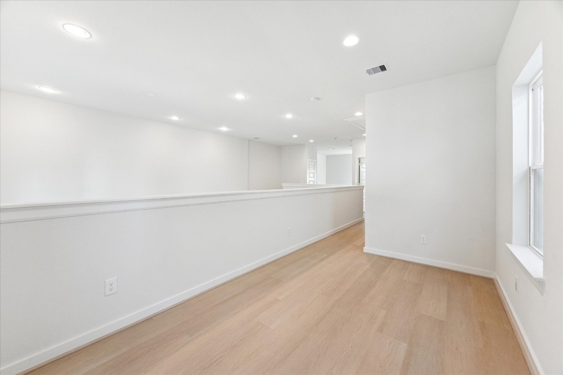 817 Thornton Road, Unit F Houston, TX 77018 - Photo 30 of 36 an empty room with wooden floor and windows