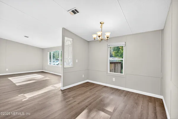 an empty room with wooden floor and window