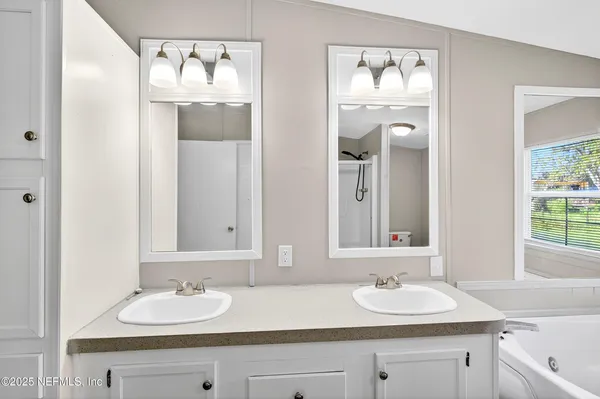 a bathroom with double vanity sinks and a mirror