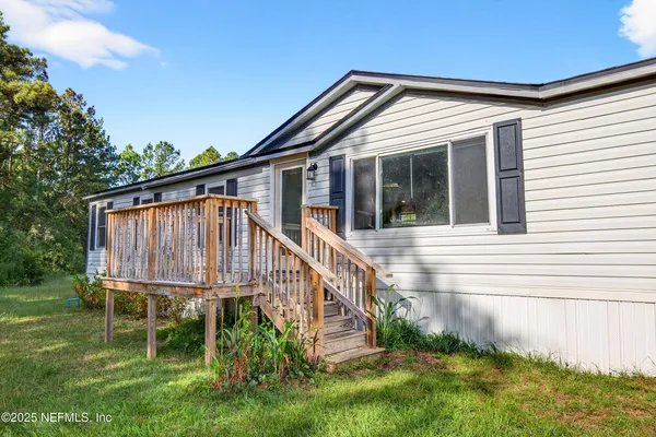 a front view of a house with a yard and deck