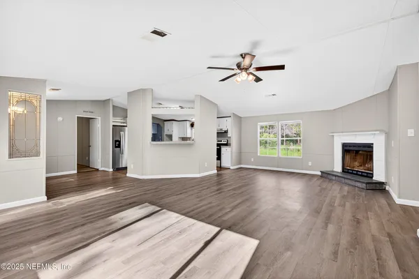 a view of empty room with wooden floor and fireplace