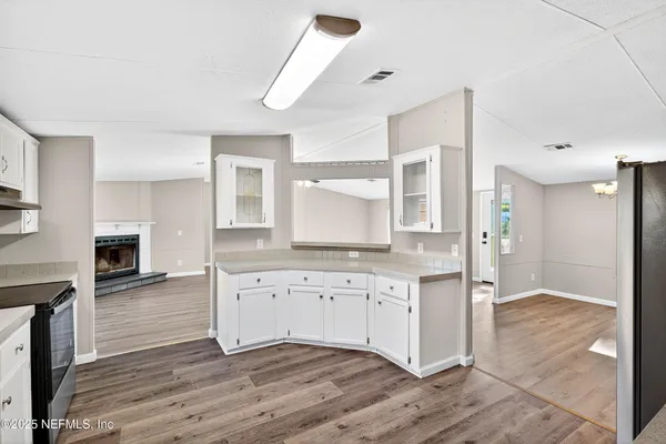 a kitchen with granite countertop a stove a sink and a refrigerator