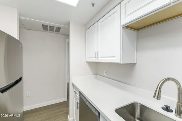 an empty room with wooden floor chandelier fan and windows