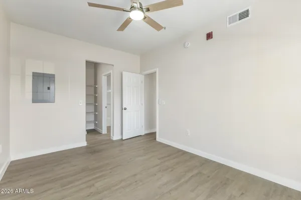 an empty room with closet and windows