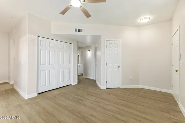 an empty room with wooden floor and closet area