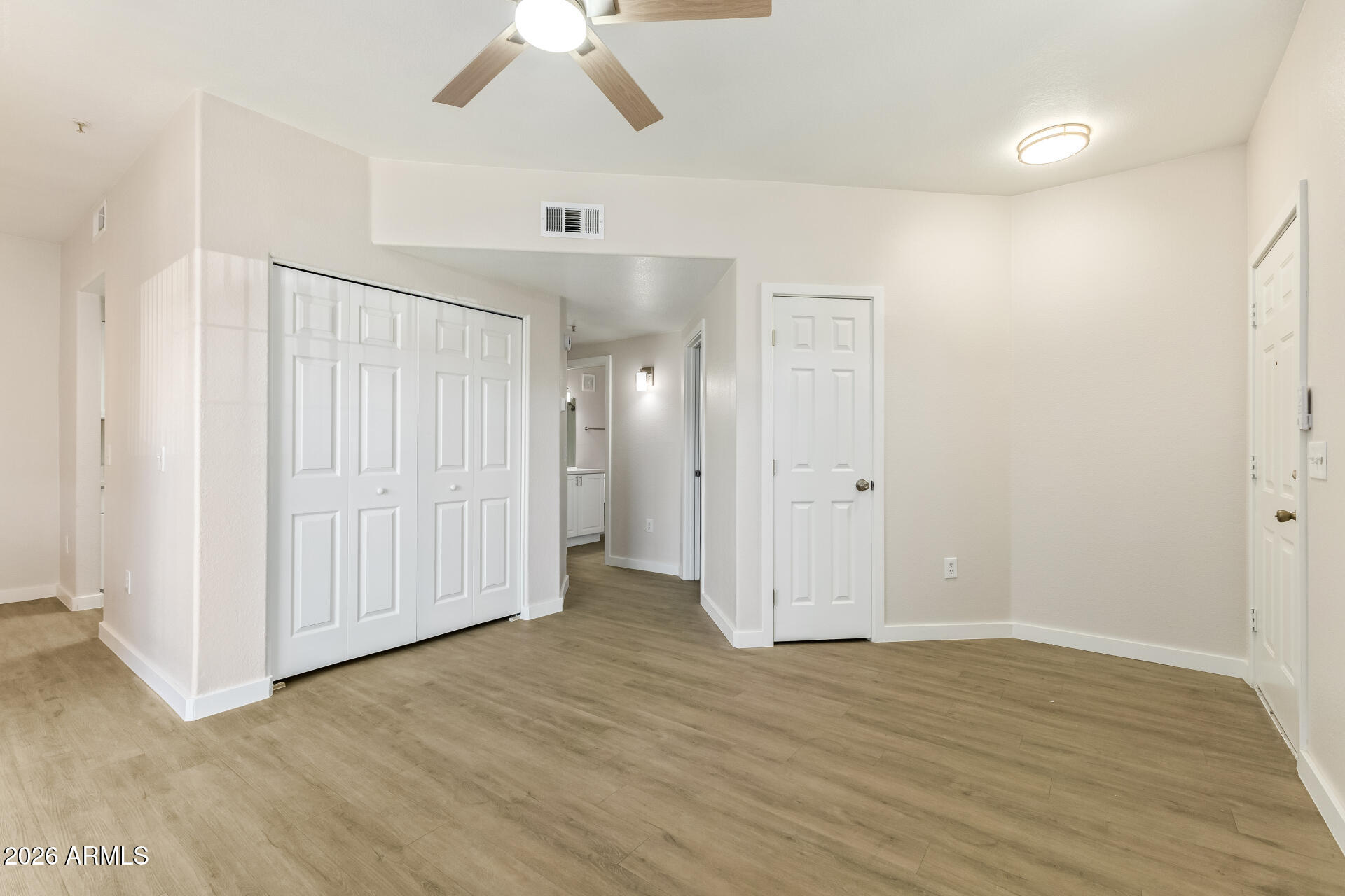 3434 East Baseline Road, Unit 109 Phoenix, AZ 85042 - Photo 4 of 40 an empty room with wooden floor and closet area