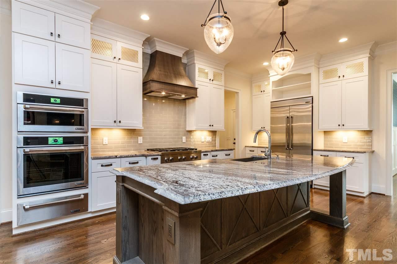 4405 Gates Street Raleigh, NC 27609 - Photo 2 of 18 a kitchen with kitchen island a stove a sink and wooden floor