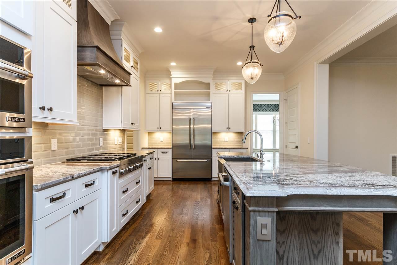 4405 Gates Street Raleigh, NC 27609 - Photo 4 of 18 a kitchen with granite countertop wooden floors cabinets a sink and appliances