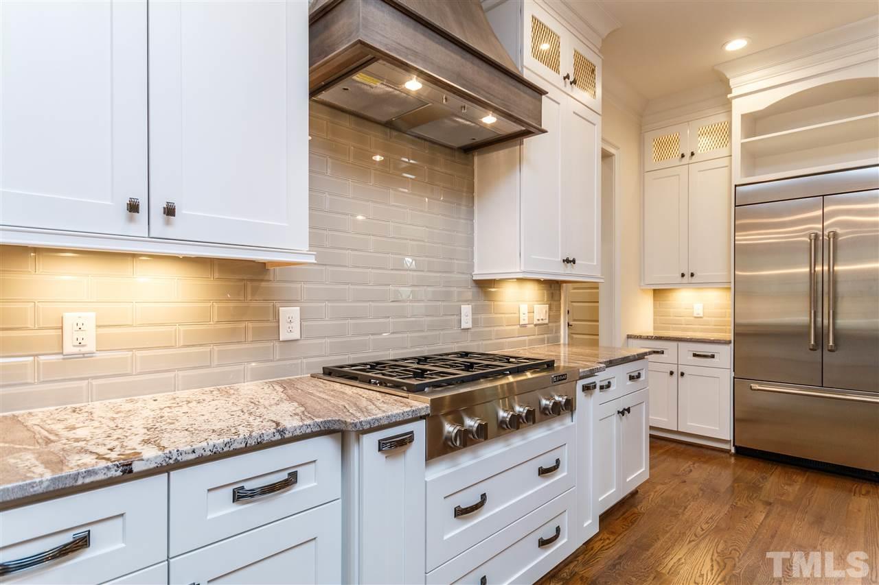 4405 Gates Street Raleigh, NC 27609 - Photo 5 of 18 a kitchen with granite countertop stainless steel appliances a stove a sink and a refrigerator
