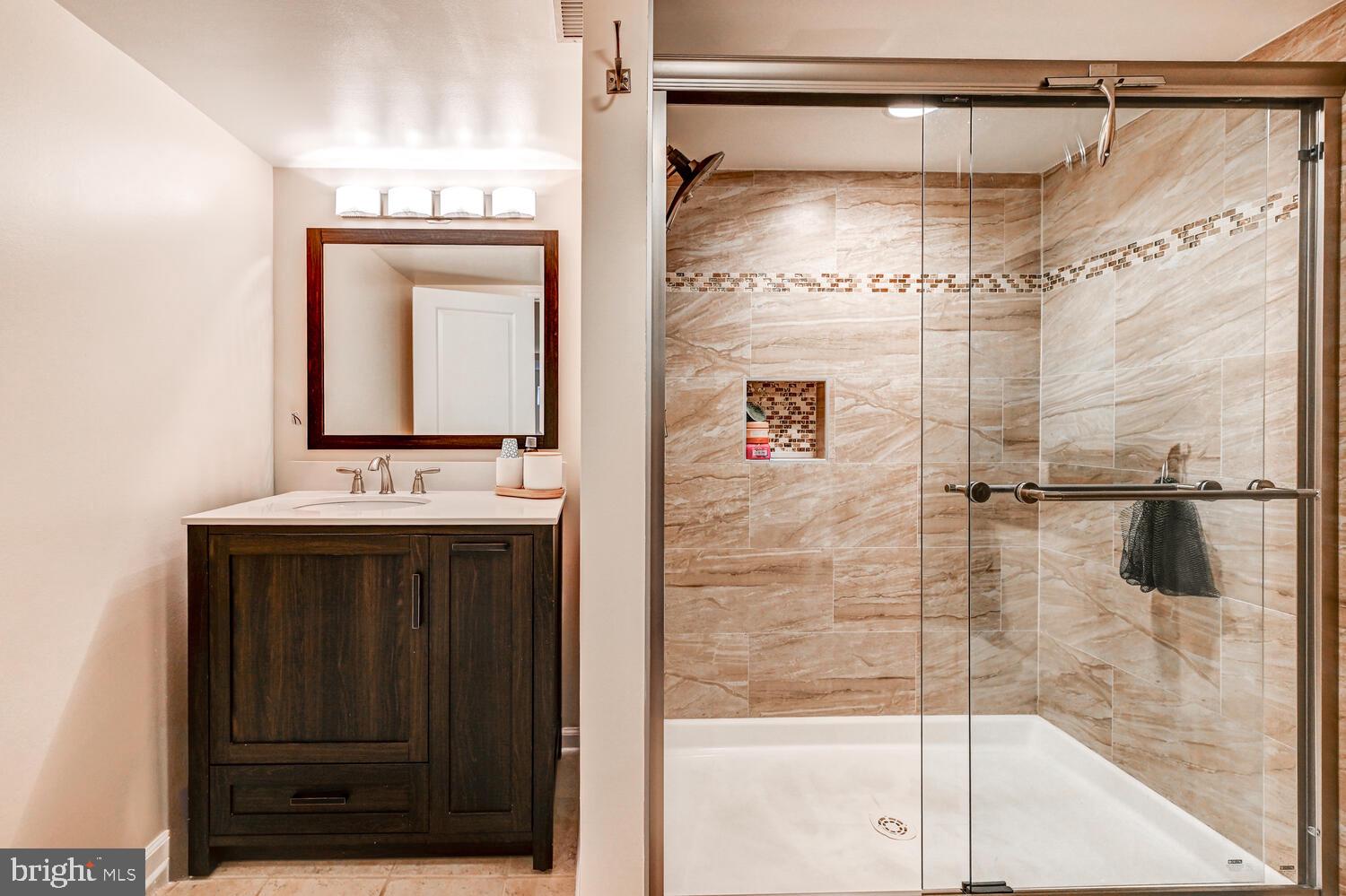 6420 Kenwood Avenue Rosedale, MD 21237 - Photo 18 of 22 a bathroom with a shower a mirror and a sink